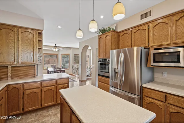 a view of an empty room with chandelier fan and a ceiling fan