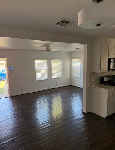 a view of empty room with wooden floor