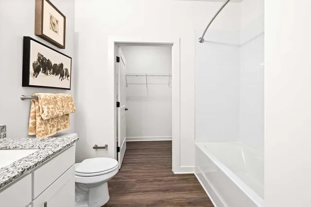 a bathroom with a granite countertop toilet a sink and bathtub
