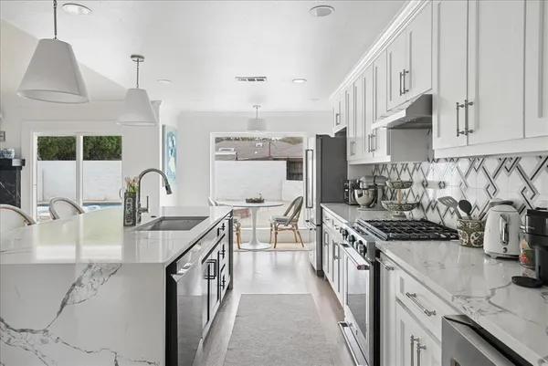 a kitchen with stainless steel appliances granite countertop a sink stove and cabinets