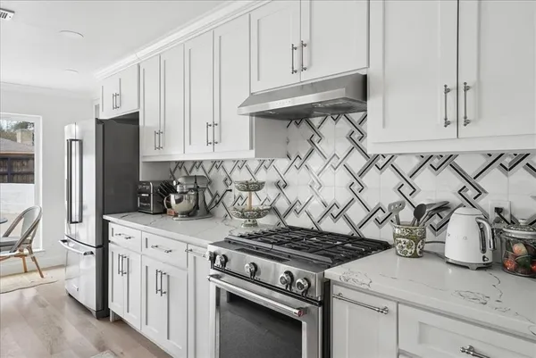 a kitchen with white cabinets and a stove top oven