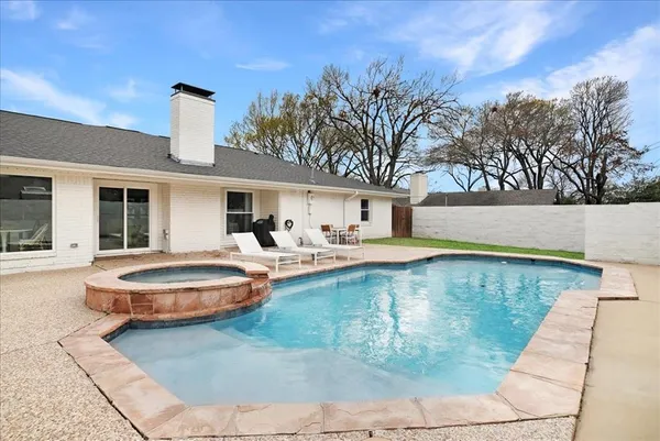 a front view of a house with swimming pool having outdoor seating