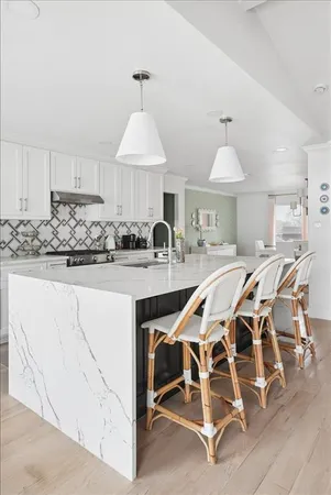 a kitchen with kitchen island granite countertop a sink and a stove