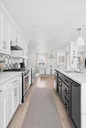 a kitchen with stainless steel appliances a sink stove and cabinets