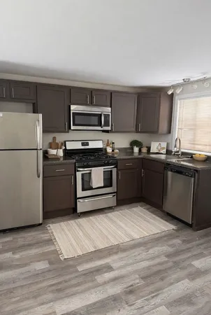 a kitchen with stainless steel appliances granite countertop a stove a sink and a refrigerator