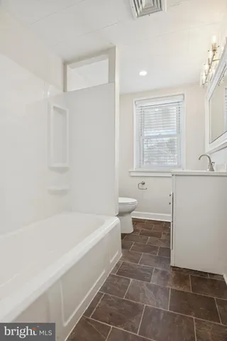 a bathroom with a bathtub and toilet