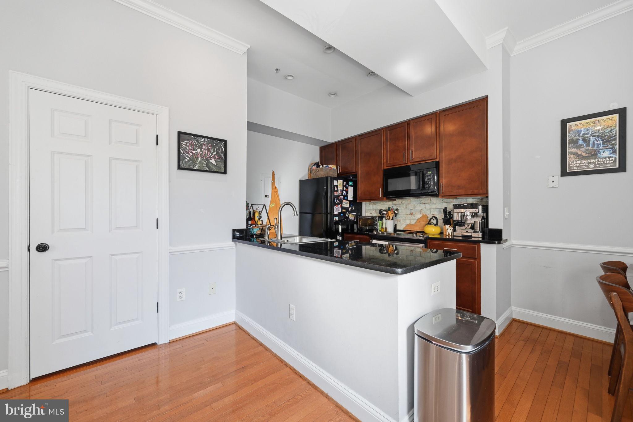 1229 12th Street Northwest, Unit 208 Washington, DC 20005 - Photo 2 of 35 a kitchen with granite countertop a sink stove and microwave
