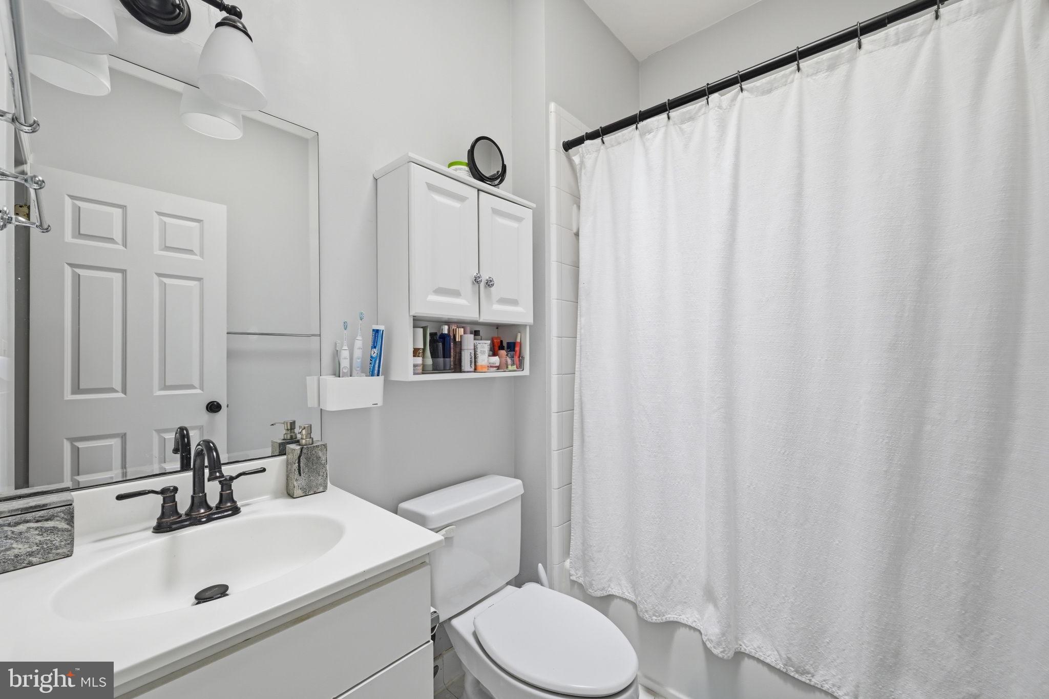 1229 12th Street Northwest, Unit 208 Washington, DC 20005 - Photo 33 of 35 a bathroom with a sink a toilet and shower curtain