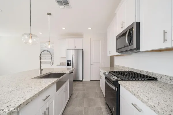 a kitchen with stainless steel appliances granite countertop a sink stove and refrigerator