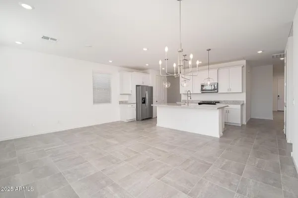 a view of kitchen with kitchen island a sink stainless steel appliances and cabinets