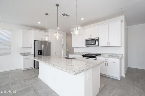 a kitchen with stainless steel appliances granite countertop a sink a stove a refrigerator and a oven