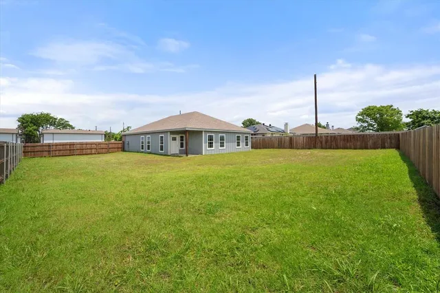 a view of a house with a big yard and large trees
