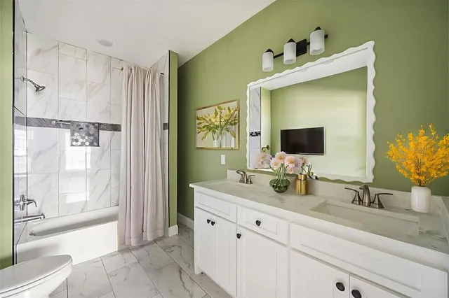 a bathroom with a double vanity sink mirror and bathtub