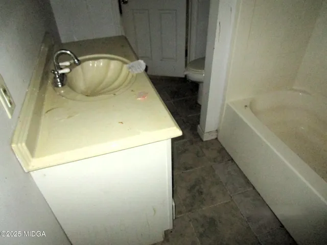 a white toilet sitting next to a bath tub