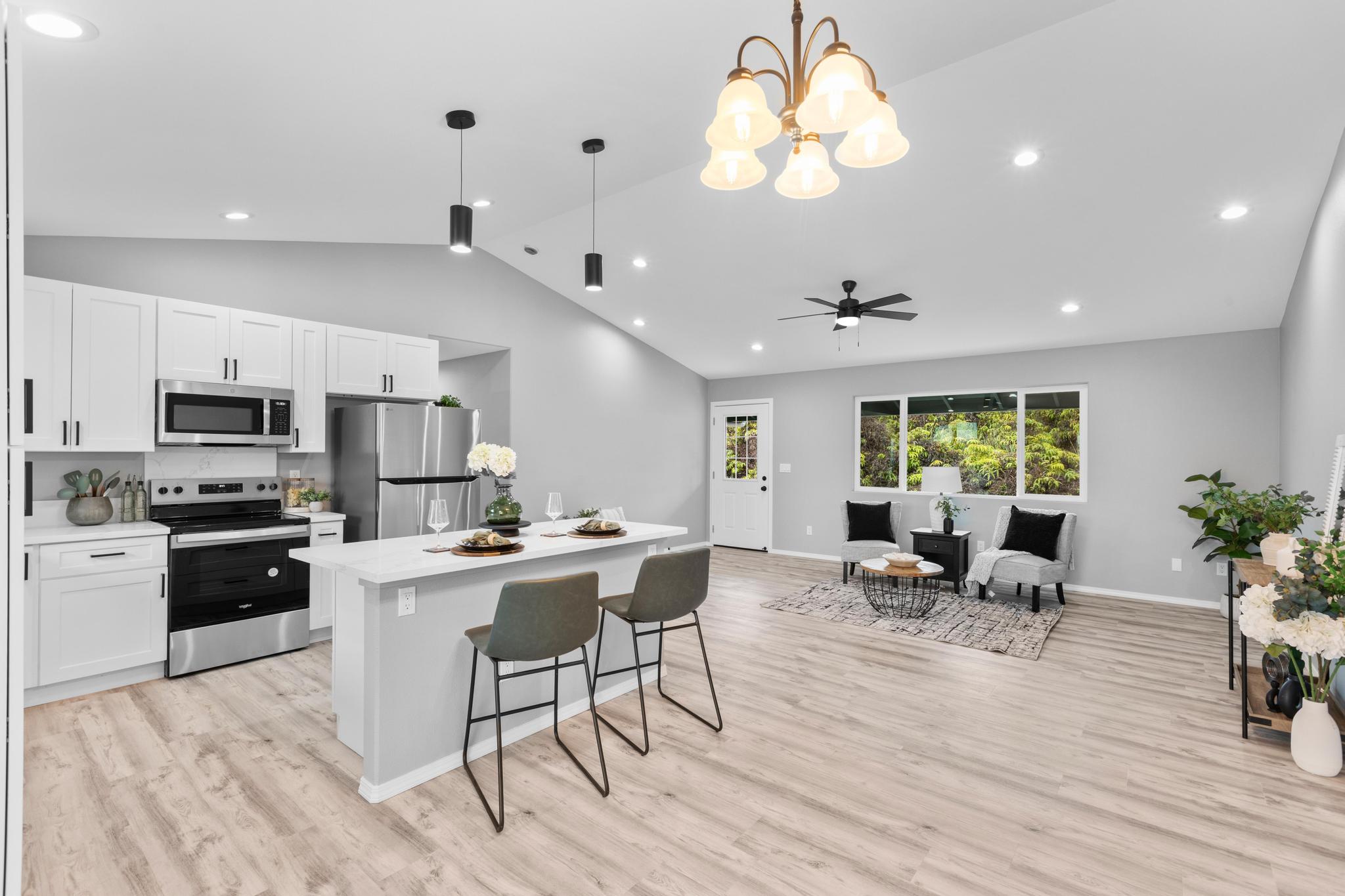11-3343 Volcano Road Volcano, HI 96785 - Photo 2 of 30 a kitchen with stainless steel appliances kitchen island granite countertop a stove top oven a sink a dining table and chairs with wooden floor