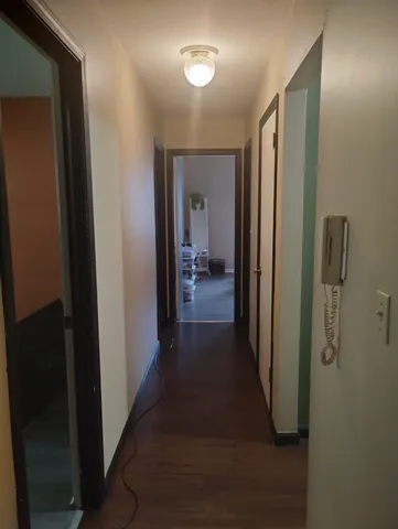 a view of a hallway with wooden floor and closet