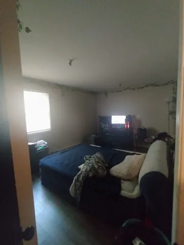 a bed sitting in a bedroom next to a lamp