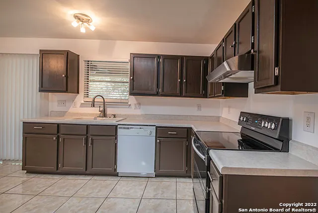a kitchen with stainless steel appliances granite countertop a sink and a stove