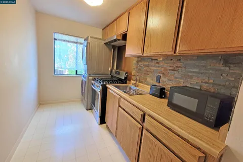 a kitchen with a sink a stove and cabinets