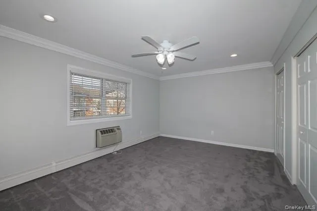 an empty room with a window and a ceiling fan