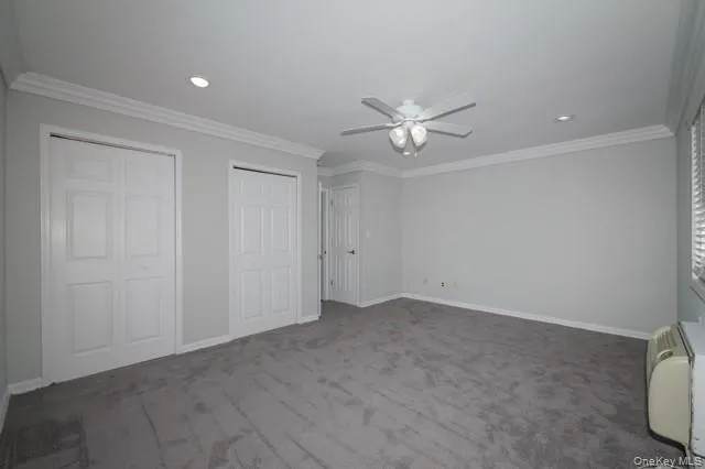 an empty room with a ceiling fan and a window