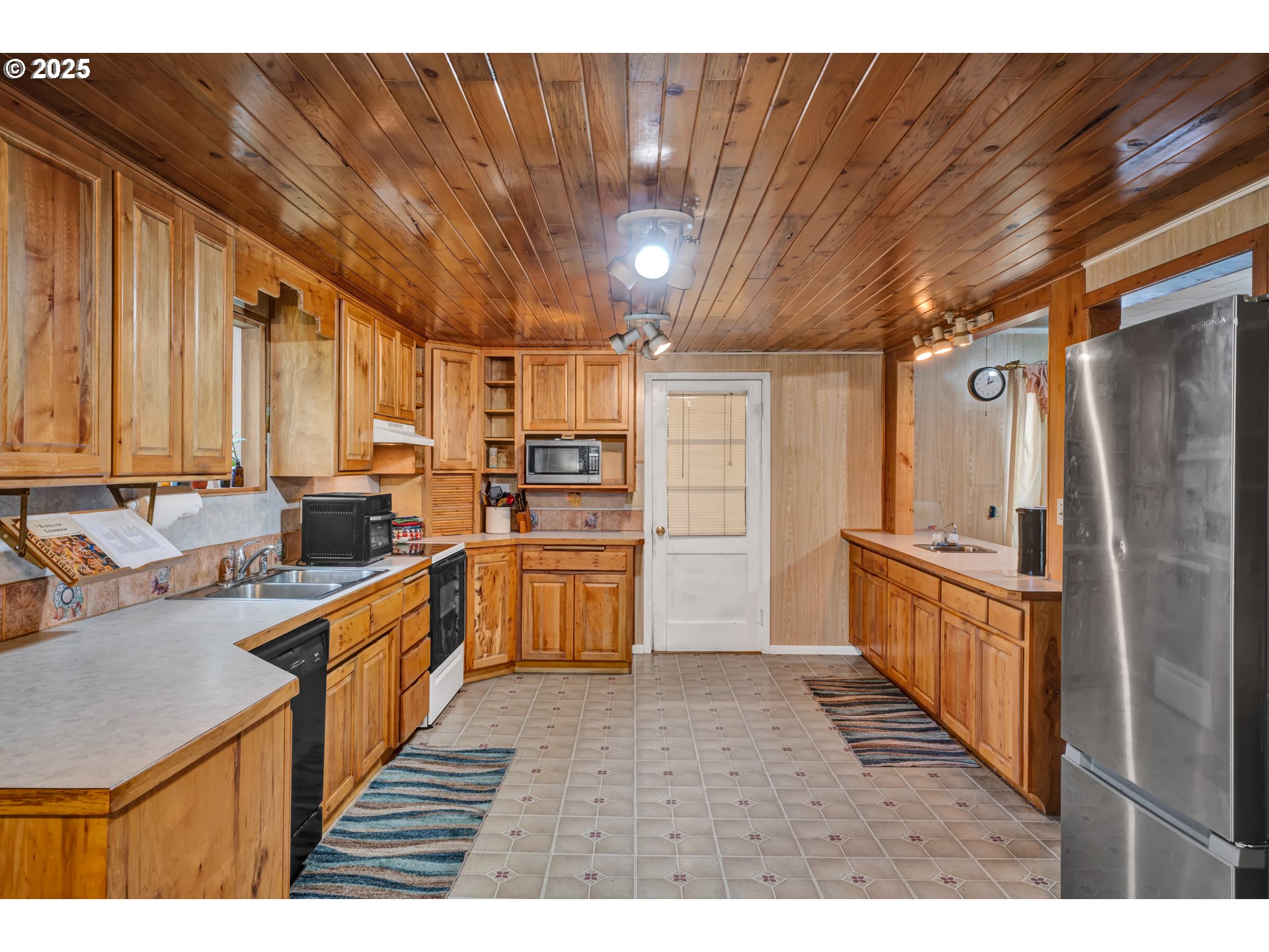 32253 Deberry Road Creswell, OR 97426 - Photo 18 of 43 a kitchen with stainless steel appliances kitchen island granite countertop a refrigerator a stove and a sink with wooden cabinets