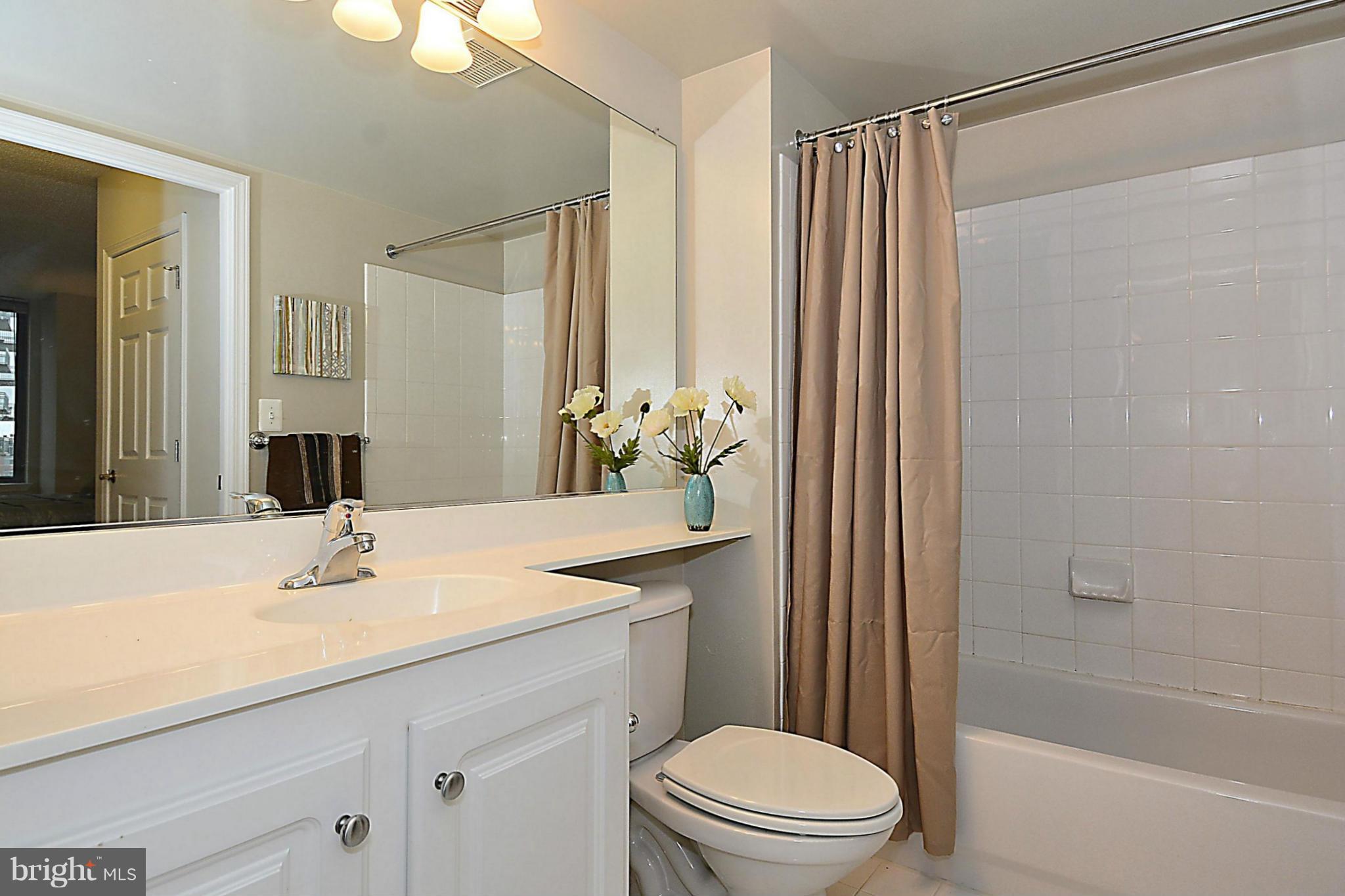 11710 Old Georgetown Road, Unit 419 North Bethesda, MD 20852 - Photo 15 of 30 a bathroom with a sink a toilet and shower