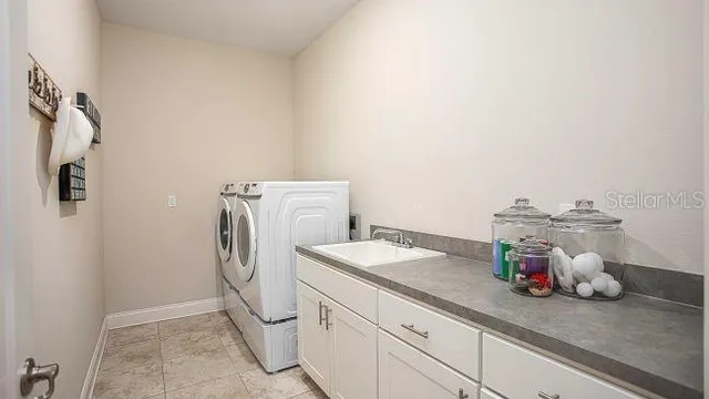 a utility room with cabinets washer and dryer