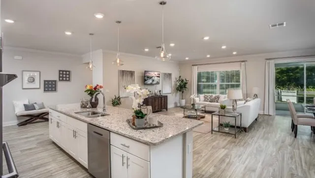 a large kitchen with kitchen island a large counter top space a sink stainless steel appliances and cabinets