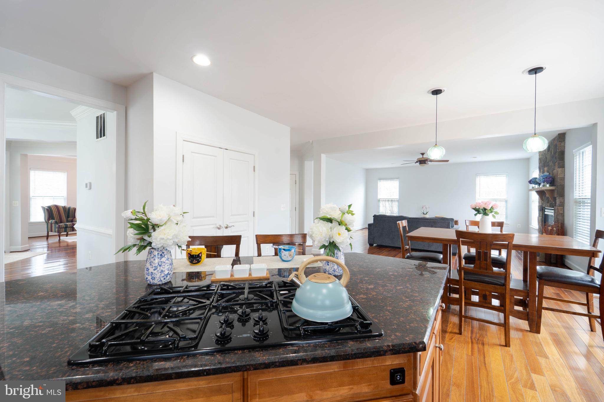16309 Sandy Ridge Court Woodbridge, VA 22191 - Photo 21 of 93 a kitchen with stainless steel appliances granite countertop a stove top oven a dining table and chairs with wooden floor