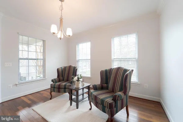 a view of a dining room with furniture a chandelier and wooden floor