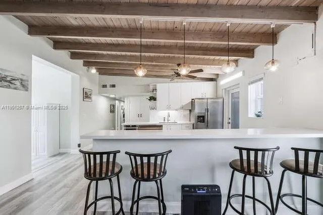 a kitchen with stainless steel appliances a table and chairs in it