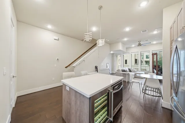 a kitchen with a stove a refrigerator and a dining table with wooden floor