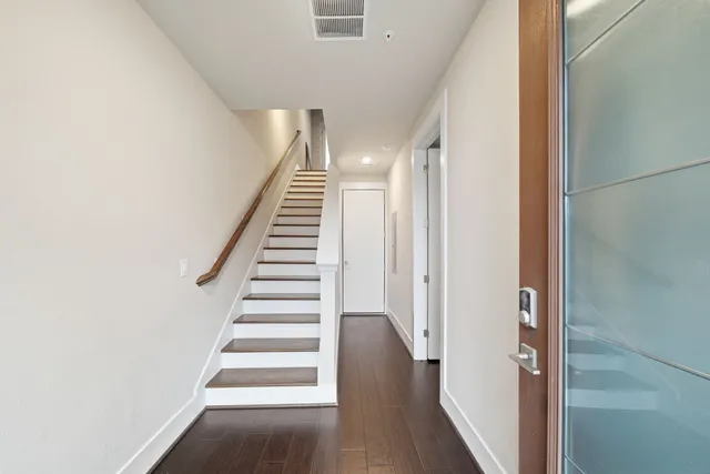 a view of a hallway with wooden floor and entryway