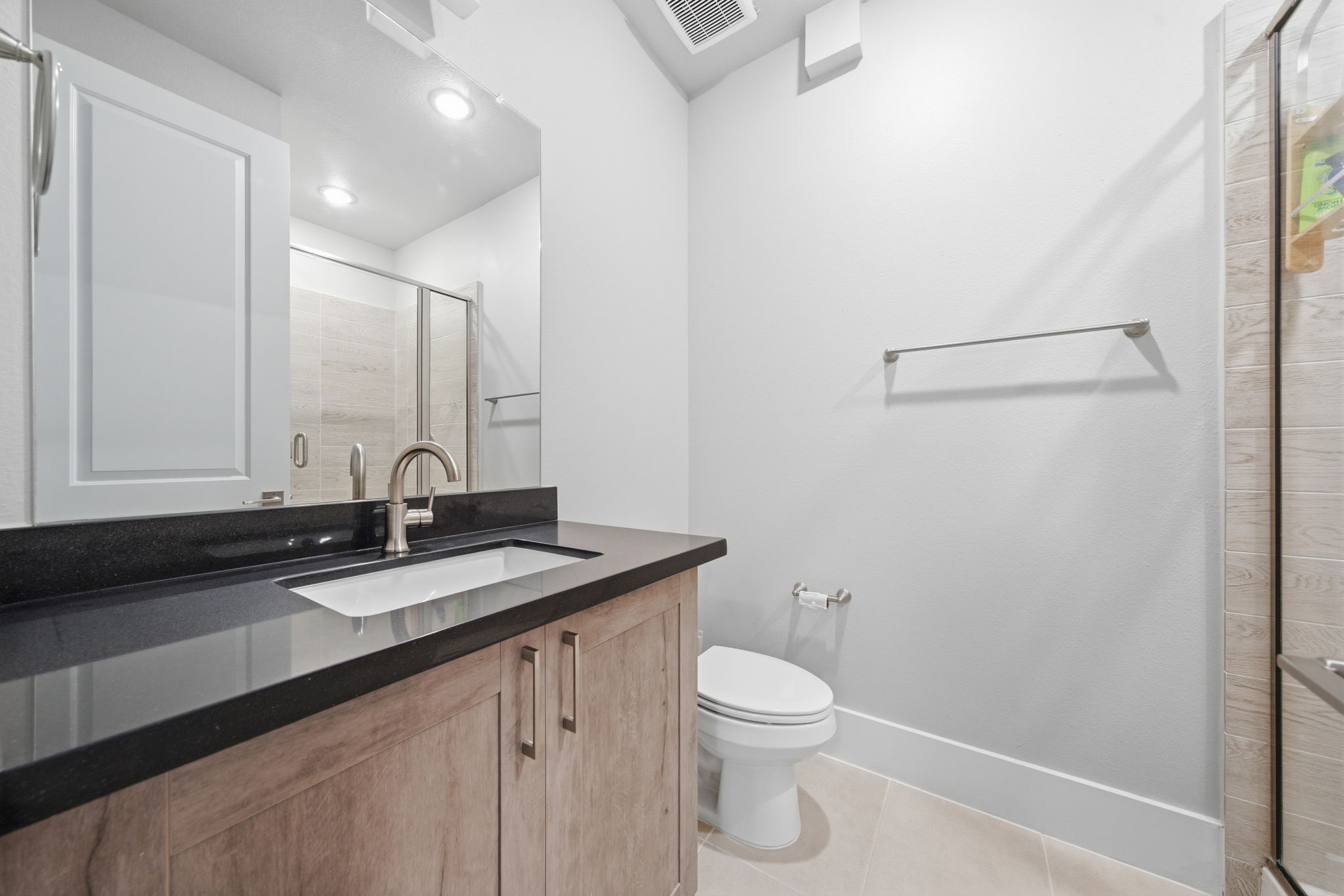 2401 Crawford Street, Unit C1C Houston, TX 77004 - Photo 5 of 24 a bathroom with a granite countertop sink a toilet and a mirror