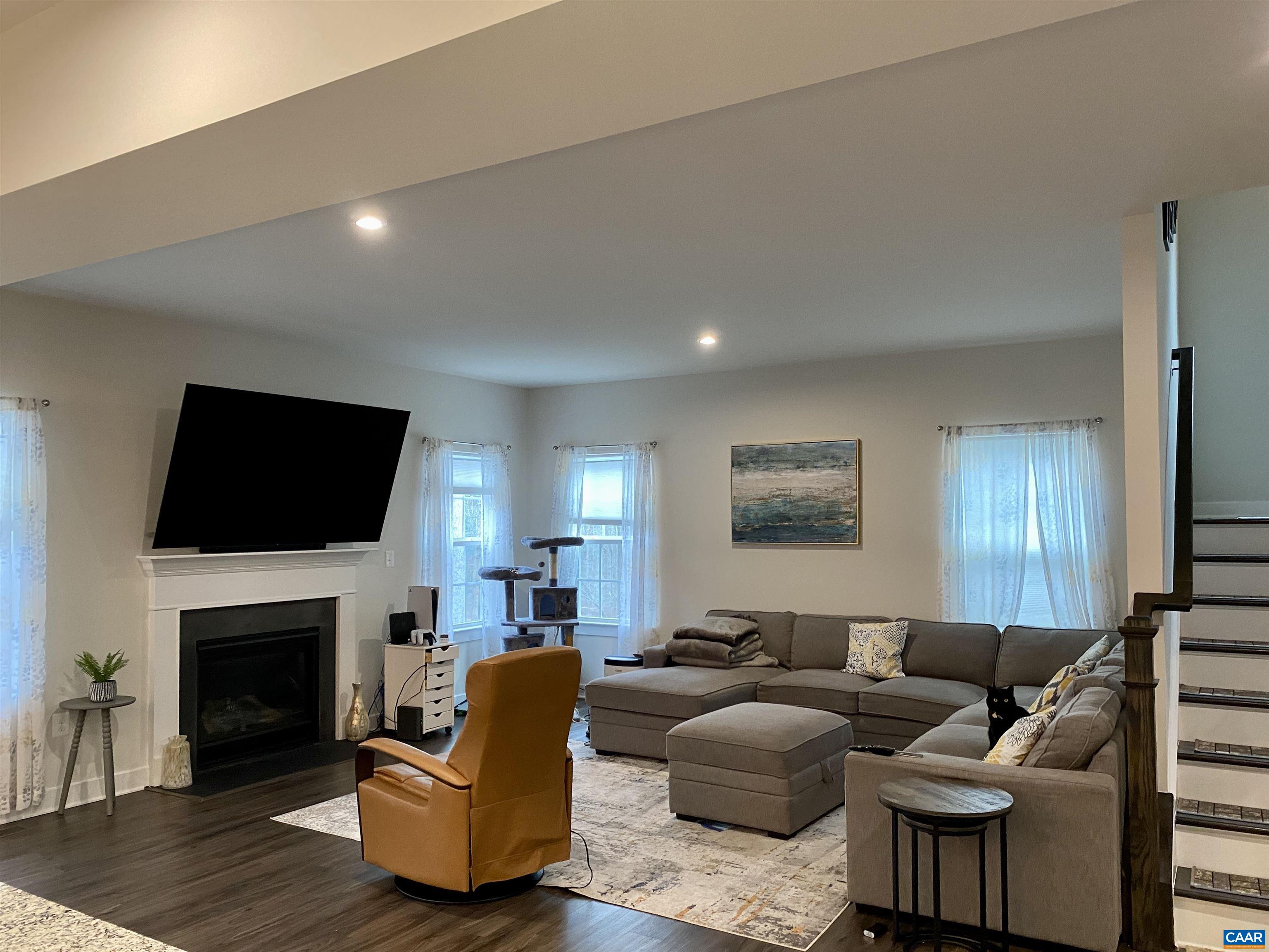 3402 Steamer Drive Keswick, VA 22947 - Photo 10 of 27 a living room with furniture a fireplace and a flat screen tv