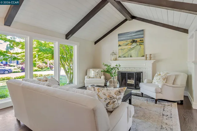 a living room with furniture a fireplace and a large window