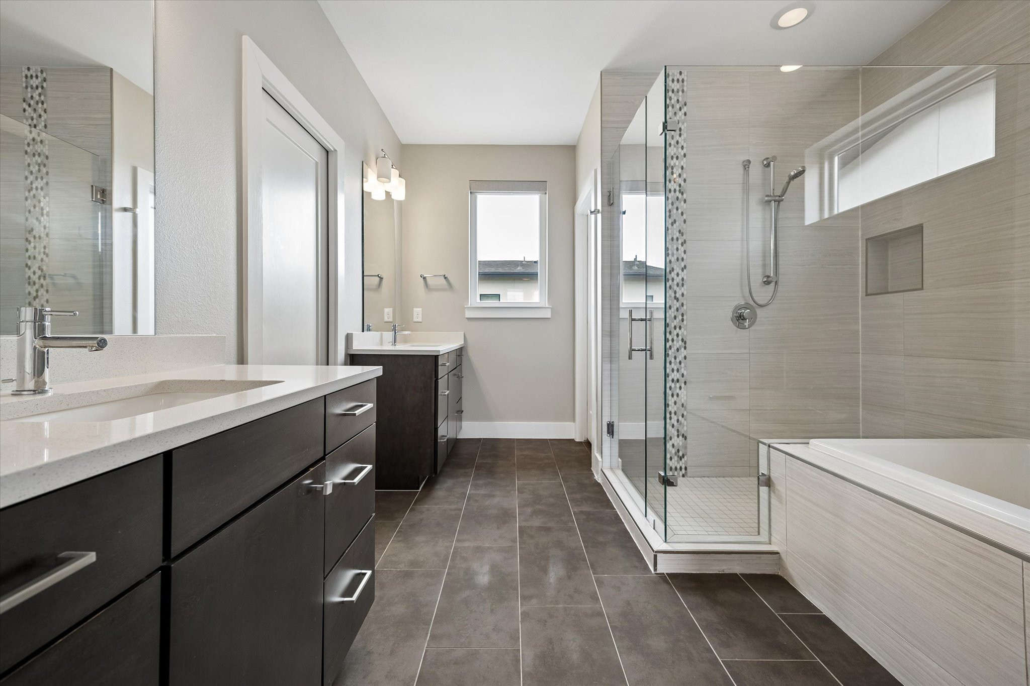 5006 Pecan Springs Road, Unit 6 Austin, TX 78723 - Photo 18 of 30 A primary bathroom features dual vanities, a spacious glass-enclosed shower, and a built-in soaking tub.
