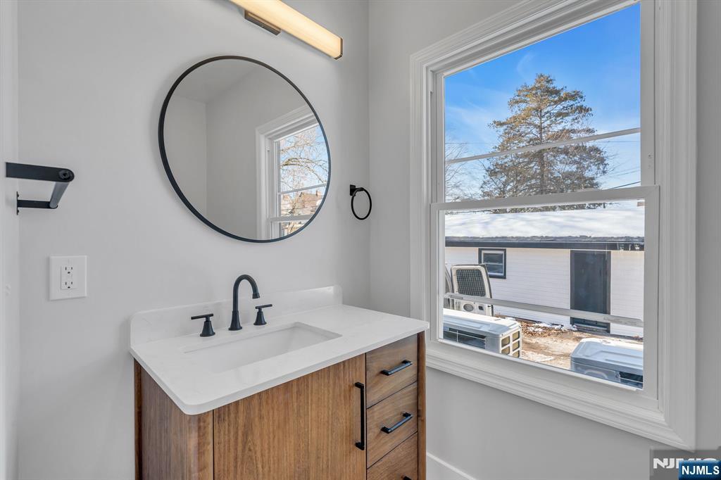 12 Enfield Avenue Montclair, NJ 07042 - Photo 16 of 50 a bathroom with a sink a mirror and a painting on the wall