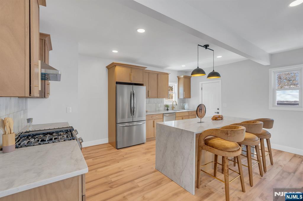 12 Enfield Avenue Montclair, NJ 07042 - Photo 18 of 50 a kitchen with stainless steel appliances granite countertop a refrigerator a sink a stove a dining table and chairs