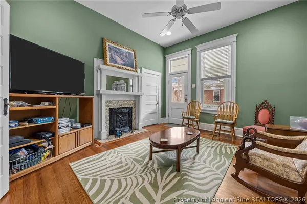 a living room with furniture a flat screen tv and a fireplace