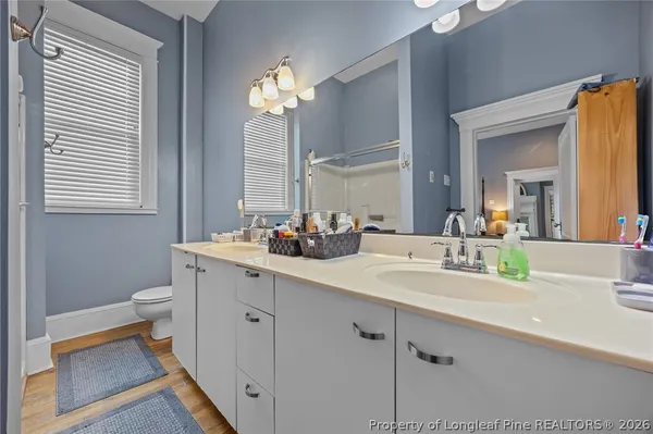a bathroom with a double vanity sink mirror and toilet