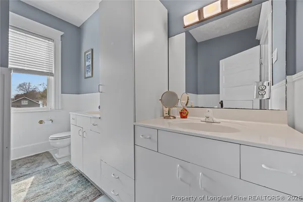 a bathroom with a toilet sink and mirror