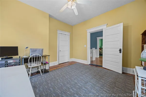 a view of a bedroom with a furniture and wooden floor