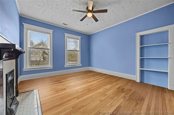 a view of an empty room with a window and wooden floor