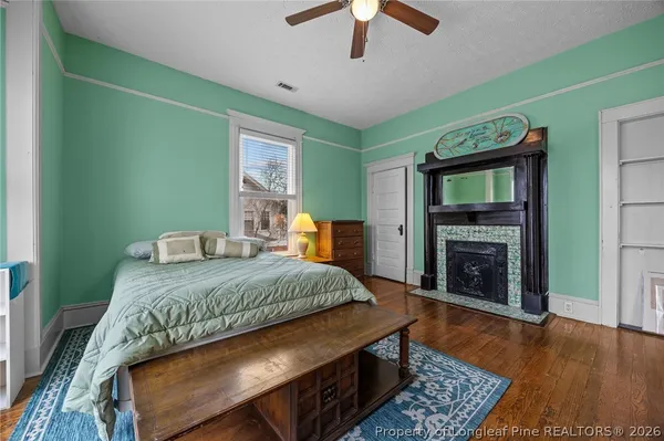 a bedroom with a bed dresser and a fireplace