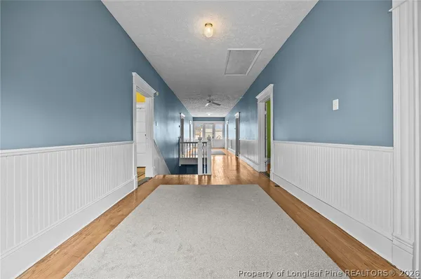 a view of a hallway with a chair and chandelier