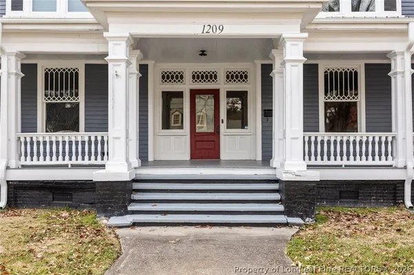 a front view of a house with a large window and stairs