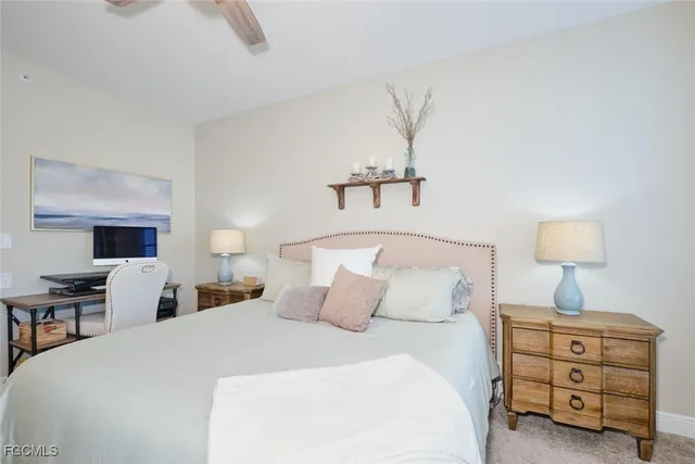 a bedroom with bed and a lamp on dresser