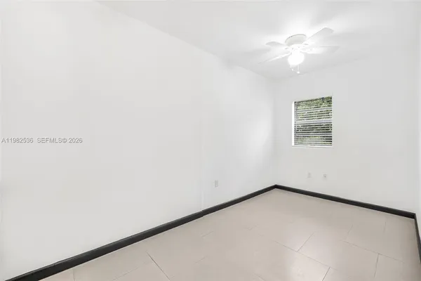 an empty room with a window and a ceiling fan